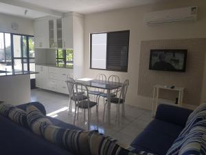 a living room with a blue couch and a table at CONFORTO e SEGURANÇA AP11 in Guaratuba