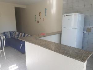 a kitchen with a counter and a white refrigerator at CONFORTO e SEGURANÇA AP11 in Guaratuba