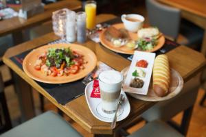 een houten tafel met borden eten erop bij Villa Sterrebosch - boutique hotel - 1 suite - centrum Wijchen in Wijchen