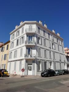 a white building with cars parked in front of it at Cannes la bocca appartement in Cannes