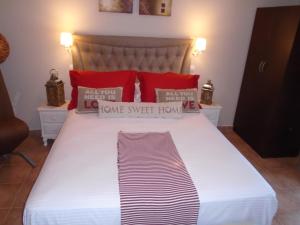 a bedroom with a large bed with red pillows at Machi Rooms in Patitiri