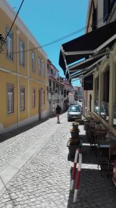 une rue pavée avec des tables et des chaises dans l'établissement Casa Joana B&B, à Cascais
