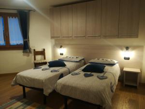two twin beds in a room with two at Casa Betty in Bormio