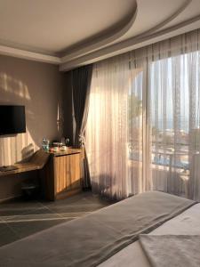a bedroom with a bed and a large window at Grand Vuslat Erdek in Erdek