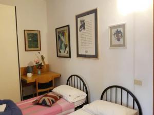 シエナにあるBed in Sienaのテーブルと鏡付きの部屋のベッド2台