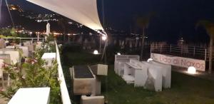a group of white tables and chairs at night at B&B Di Marco in Giardini Naxos