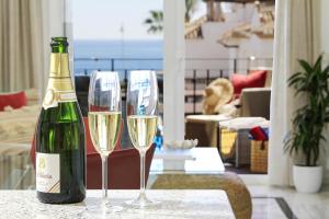 una botella de champán y dos copas de vino en una mesa en Casa de la playa Alto de el Realengo, en La Herradura