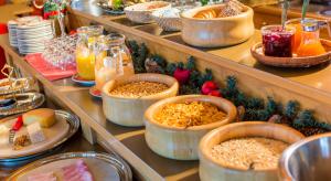 a buffet filled with bowls of food on display at Familienhotel Garni Sporting in Bettmeralp