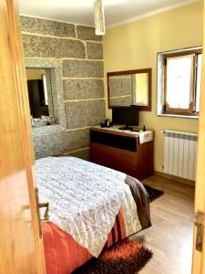 1 dormitorio con cama, tocador y espejo en Chambre de la tour - Quinta da Prelada Simão, en Celorico de Basto