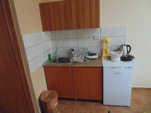 a small kitchen with a sink and a refrigerator at Elisian Studios in Néa Karváli