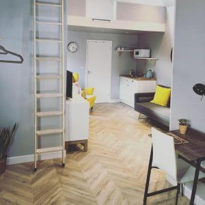 a living room with a ladder and a kitchen at The Rhubarb Room in Barston