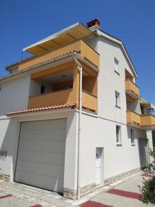 a white apartment building with a garage at Apartments Palit in Rab