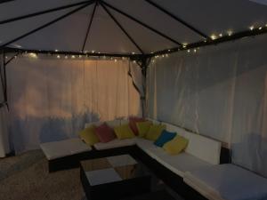 a couch with colorful pillows in a tent at Apartments Ana & Ita in Novalja