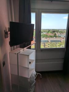TV en un tocador en una habitación con ventana en FeWo Köln en Colonia