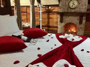 um quarto com uma cama com lençóis vermelhos e uma lareira em Mirágua Refugios Pousada em Brotas