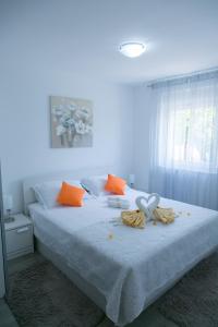a bedroom with a bed with orange and white pillows at Navi in Kaštela