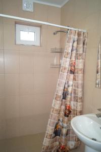 a bathroom with a shower curtain and a sink at Валентина in Gagra