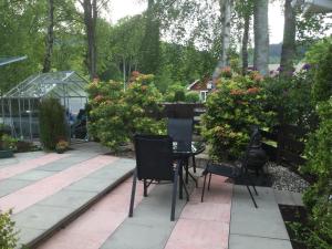 a patio with chairs and flowers in a garden at Bunillidh in Drumnadrochit