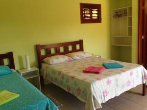 una camera con un letto con due cuscini sopra di Pousada Muiraquitã a Beberibe