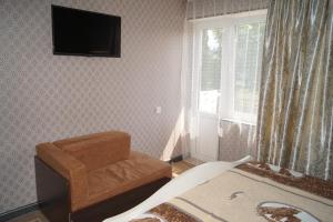 a bedroom with a bed and a television on the wall at Валентина in Gagra
