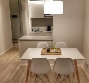 einen weißen Esstisch mit Stühlen und eine Küche in der Unterkunft Fabuloso departamento con todo y cerca de todo in Buenos Aires