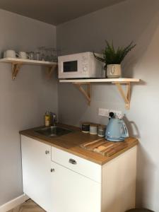 a small kitchen with a sink and a microwave at The Rhubarb Room in Barston