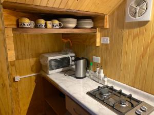 una piccola cucina con piano cottura e forno a microonde di Hostal Patagonia Marmol a Coihaique