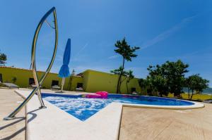 een zwembad in een tuin met een blauwe bij Apartments Petra in Trogir
