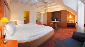 a bedroom with a large white bed and a chair at Haus am Meer Steinhude in Steinhude