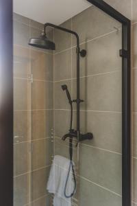 een douche met een douchekop in de badkamer bij MONO Suites Old Town in Edinburgh