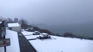 Glandore的住宿－格蘭多爾灣景住宿加早餐旅館，雪上覆盖的一组野餐桌
