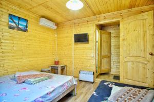 um quarto com uma cama e uma televisão numa parede de madeira em Motel MaksiM-4 DON em Pavlovsk