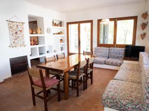 Casa Sa Serreta في سانت فيران دي سيس روكيه: غرفة طعام مع طاولة وكراسي وأريكة