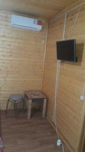 Habitación con mesa, TV y taburete. en Motel MaksiM-4 DON en Pavlovsk