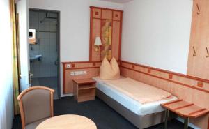 ein kleines Zimmer mit einem Bett und einer Dusche in der Unterkunft Hotel Wetterau in Wölfersheim