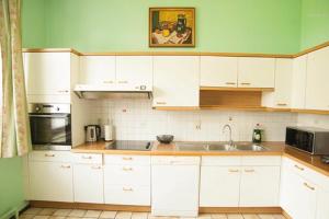 a kitchen with white cabinets and a sink at Voisins du kayak in Dinant