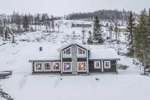 a house is covered in snow with trees at Rolfhytta - Fosskamben 19 in Sogndal