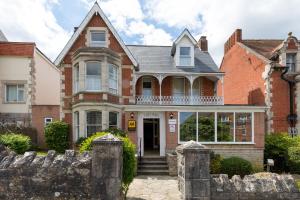 an old brick house with a stone fence at The Limes in Swanage