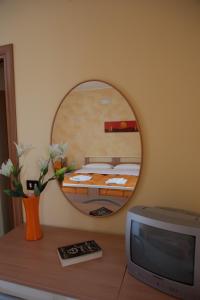 a room with a mirror and a tv on a table at B&B Casa Mauro in Linguaglossa