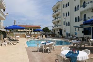 a patio with tables and chairs next to a swimming pool at Eroglu City Hotel in Fethiye