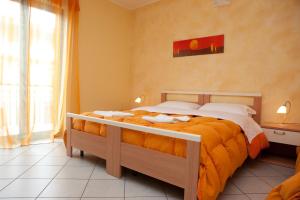 1 dormitorio con 1 cama grande con sábanas de color naranja en B&B Casa Mauro, en Linguaglossa
