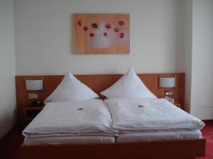 a bed with two white pillows in a room at Panorama Hotel am Frankenstein in Bad Salzungen +15 photos