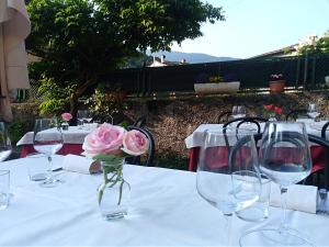 albergo ristorante coppa في Dazio: طاولة مع نظارة وورد وردي في مزهرية