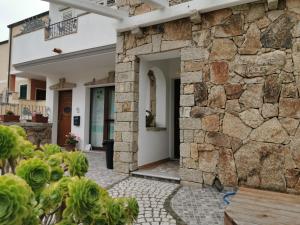 une façade en pierre d'une maison avec un mur en pierre dans l'établissement Bed & Breakfast Mare Isole, à La Maddalena
