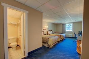 a hotel room with two beds and a bathroom at Village Inn in Annapolis