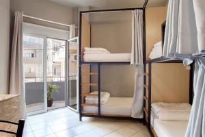 a room with bunk beds and a balcony at So Young Hostel in Heraklio Town