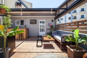 an outdoor patio with a couch and a tv at So Young Hostel in Heraklio Town