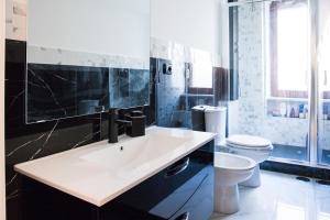 La salle de bains est pourvue d'un lavabo blanc et de toilettes. dans l'établissement Salerno Apartments, à Salerne