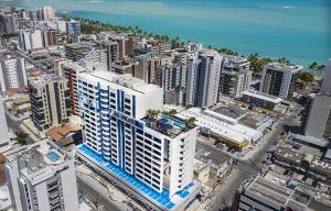 una vista aérea de una ciudad con edificios y el océano en Edifício Time - Apto 517 en Maceió