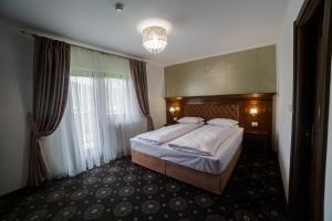 A bed or beds in a room at Grădina Mariajelor Hotel